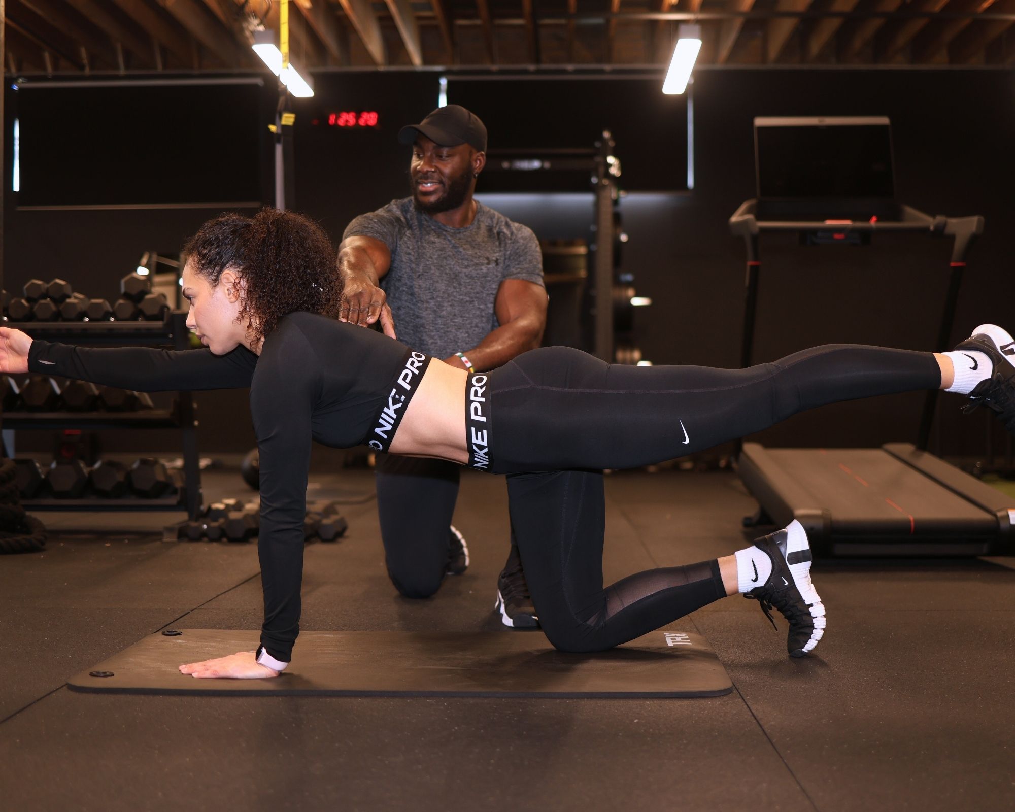 1-on-1 Denver personal trainer helping client on strength workout.