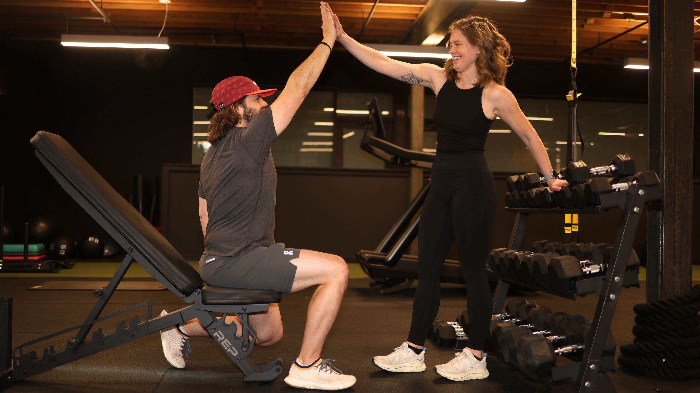 Two clients celebrating with a high five after a personal training session in Denver.